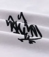 Remera de algodón con cuello redondo y manga corta. Presenta un diseño con estampa pequeña en el pecho y un gráfico estilo graffiti en la espalda.
