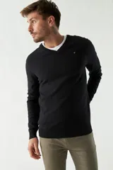 Sweater de punto color rosa con cuello en V y logo bordado en el pecho.