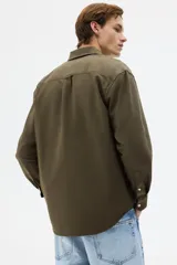 Camisa de algodón Oxford con cuello americano, tapeta clásica, bolsillo superior abierto y canesú en la espalda. Mangas largas con puños abotonados y bajo levemente redondeado.