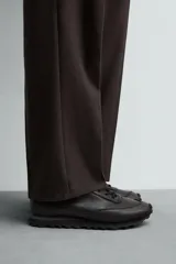 Zapatilla deportiva para hombre fabricada en piel, con diseño de paneles combinados y suela dentada.