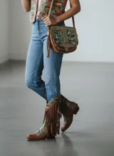 Botas tejanas de cuero color marrón terracota, con detalles pintados a mano en tonos turquesa y negro, diseño con flecos largos y puntera perfilada.