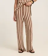 Pantalón de punto color crema con rayas verticales marrones, de corte recto y cintura alta con elástico.