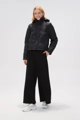 Campera acolchada de color negro con diseño de rombos, manga larga, capucha ajustable con cordones y cierre frontal con botones a presión.