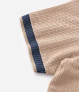 Remera de manga corta, color azul, con textura acanalada vertical. Presenta cuello redondo y puños contrastantes en color beige.