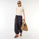 Pantalón gris de corte holgado, tiro alto y diseño tipo bombacho, con cintura elástica y bajo fruncido ajustable.