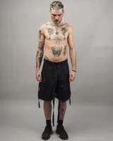 Pantalón cargo negro de gabardina, corte amplio, con múltiples bolsillos y tiras ajustables.
