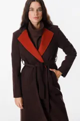 Tapado de paño en color marrón chocolate con solapas en contraste color naranja, diseño cruzado con lazo ajustable en la cintura y bolsillos laterales.