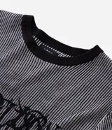 Suéter de punto con diseño de rayas verticales en tonos gris y negro, cuello redondo, manga larga y estampado frontal con la palabra Rebellion en estilo gótico.