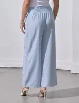 Pantalón largo de poliéster color beige con rayas verticales, pretina ancha elastizada en punto smock y pierna ancha.