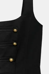 Top negro de escote cuadrado y tirantes anchos, con diseño ajustado tipo corsé y cierre trasero con cremallera. Presenta costuras marcadas y una botonera doble frontal con botones metálicos dorados.