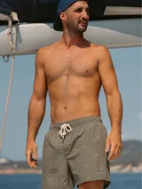 Short de baño color gris con estampado de palmeras, cintura elástica con cordón ajustable y tres bolsillos.