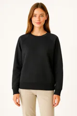 Sudadera negra de cuello redondo, manga larga tipo raglán y corte holgado.