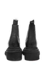 Borcego negro de cuero liso con elásticos laterales y suela de goma.