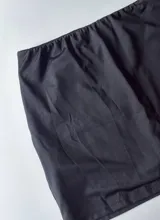 Minifalda negra con short interno y cintura elástica.