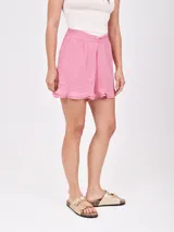 Short holgado color morado, con cintura fruncida y detalle de lazo o nudo en el frente. El ruedo tiene un ligero volante o volado.