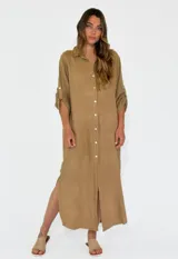 Vestido camisero largo de lino, color mostaza, con cuello camisero, cierre frontal de botones y mangas tres cuartos con detalle de tejido calado en los laterales.
