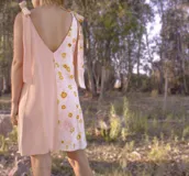 Vestido corto color verde claro, con escote en V y tiras anchas que se atan en los hombros.