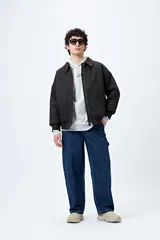 Pantalón jean negro de corte amplio y estilo carpenter, con tiro medio, bolsillos utilitarios y presillas laterales.