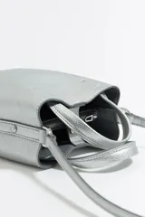 Bolso de mano mini color plateado, con doble asa corta y correa larga extraíble.