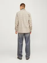 Sobrecamisa de manga larga con cierre frontal de botones y dos bolsillos con solapa en el pecho. Presenta un diseño de cuadros en tonos neutros y corte regular.