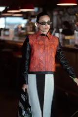 Chaqueta con cuerpo de cuero sintético rojo con estampado de piel de serpiente y mangas largas de cuero sintético negro.