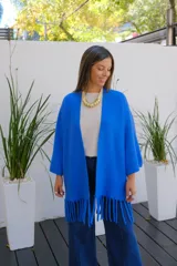 Saco abierto de punto color azul vibrante, con mangas tres cuartos y detalle de flecos largos en el ruedo.