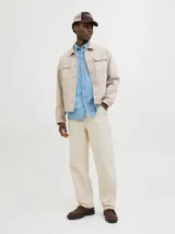 Pantalón jean color crema, corte amplio, con tiro alto, cinco bolsillos y cierre con botones.