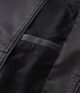 Chaqueta masculina de poliuretano color negro, con diseño de capucha, cierre frontal completo y puños elásticos. Presenta un acabado liso y estructura robusta.