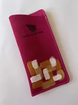 Porta lentes de cuero color fucsia de la línea Ottenta, con diseño de arte pintado a mano en tonos dorado, cobre y blanco, y logo de la marca estampado.