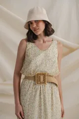 Vestido largo de gasa estampada con flores en tonos de verde y amarillo sobre fondo blanco. Tiene cintura elastizada y terminación en volados.