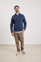 Sweater verde oliva de tejido acrílico con textura similar al cashmere, corte clásico, cuello alto con cierre metálico y tirador de cuerina ecológica.