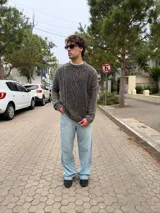 Sweater de punto con diseño de trenzas verticales, color gris oscuro con efecto lavado, de corte holgado y fit boxy, con cuello redondo y puños acanalados.