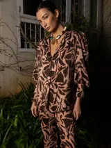 Blazer de edición limitada con estampado abstracto en tonos marrones y rosados. Presenta hombros sutilmente marcados y mangas largas con puño ancho que pueden remangarse.