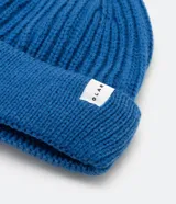 Gorro tipo fisherman de tejido acrílico con textura acanalada, diseño corto y etiqueta pequeña con logo en el frente.