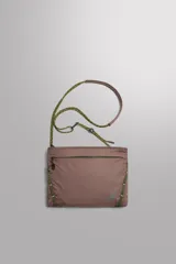 Bandolera plana de tejido técnico color marrón topo, con cierre principal y bolsillos frontales y traseros con cremallera. Incluye asa de hombro ajustable de cordón trenzado verde y marrón, con tope regulable.