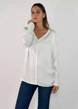Blusa de satén color blanco, con cuello en V, manga larga y corte holgado.