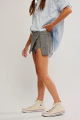 Falda pantalón corta con estampado de cuadros vichy en blanco y negro, diseño cruzado al frente y short interno.