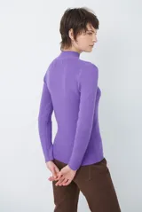 Polera de tejido morley color azul, con cuello alto y mangas largas, de corte ajustado al cuerpo.