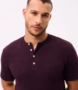 Remera Marfinno de corte regular en algodón texturizado color bordo, con cuello redondo, abertura estilo Henley con botones frontales y mangas cortas.