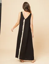 Vestido largo blanco de lino con escote en V y flecos de algodón en los bordes.