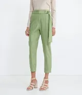 Pantalón zanahoria color verde claro, de tiro alto, con cinturón de la misma tela y hebilla doble.