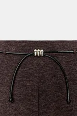 Pantalón de tiro alto y pierna recta, confeccionado en tejido piqué color beige. Presenta cintura elástica y un cinturón fino a contraste en color negro con detalle de pieza metálica central.