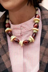 Collar corto de cuentas de resina en tonos marrón rojizo, verde claro y beige, con diseño de esferas y discos intercalados.