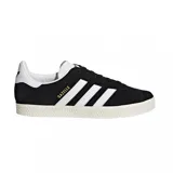 Championes Adidas modelo Gazelle, color negro con las icónicas tres tiras y talón en blanco. Presentan el nombre del modelo en letras doradas en el lateral y una suela de goma texturizada en color crema.