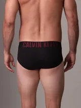 Pack de tres slips negros Calvin Klein de microfibra con cinturilla elástica con el logo de la marca en blanco, rosa y rojo. Confeccionados con un 88% de poliéster reciclado.