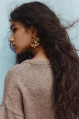 Buzo de punto suave color marrón, de corte holgado, con cuello redondo acanalado, hombros caídos y mangas cortas.