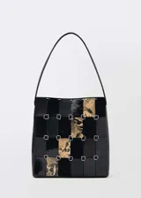 Bolso de hombro con diseño patchwork que combina paneles de cuero negro liso, cuero negro texturizado y cuero con estampado de serpiente. Presenta una estructura rígida unida por anillas metálicas plateadas y cuenta con una única asa superior.