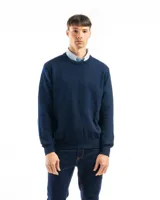 Buzo de punto liso color negro, con cuello redondo y puños y ruedo acanalados. Se lleva sobre una camisa celeste de vestir.