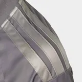 Camiseta deportiva Adidas de la escudería Audi F1 Team, color gris con detalles en plateado. Presenta cuello redondo, mangas cortas con las icónicas tres tiras de la marca en los hombros y logotipos estampados de Audi, Revolut y Pirelli en el frente y mangas.