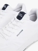 Zapatillas deportivas bajas de running, color blanco, con exterior de punto canalé transpirable y flexible. Presentan un diseño de corte bajo con cordones y suela gruesa de EVA. Llevan el logo del monotipo Hilfiger en el lateral.